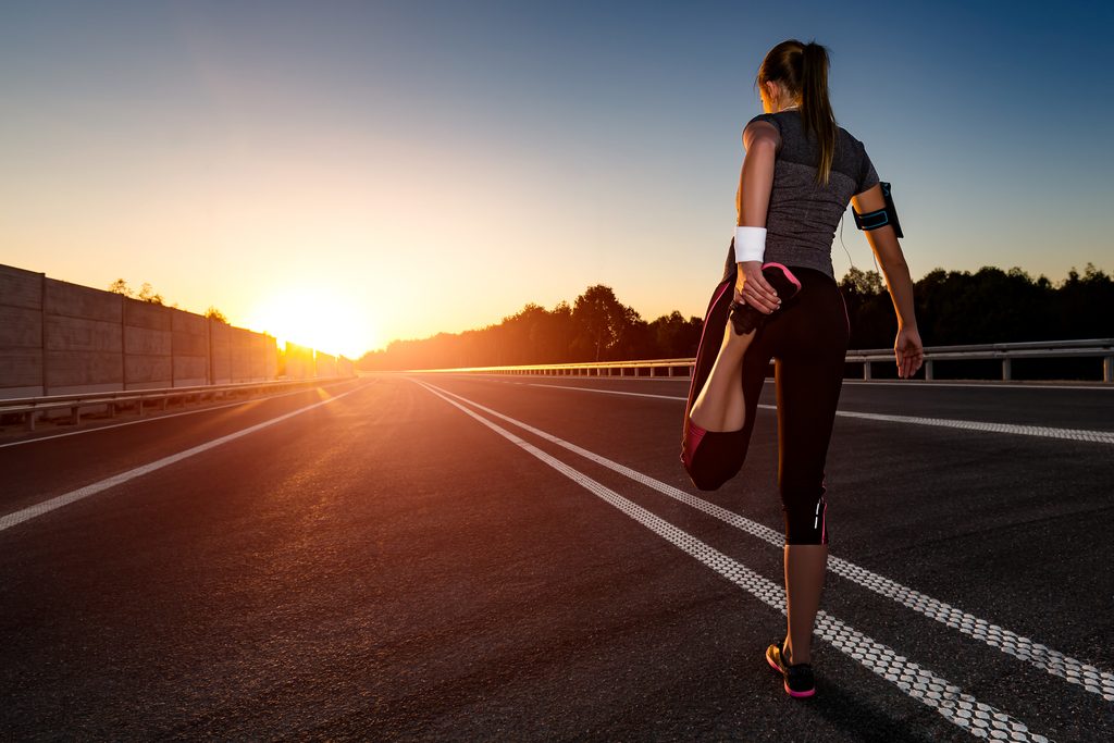 Photo of a female runner stretching before beginning a race